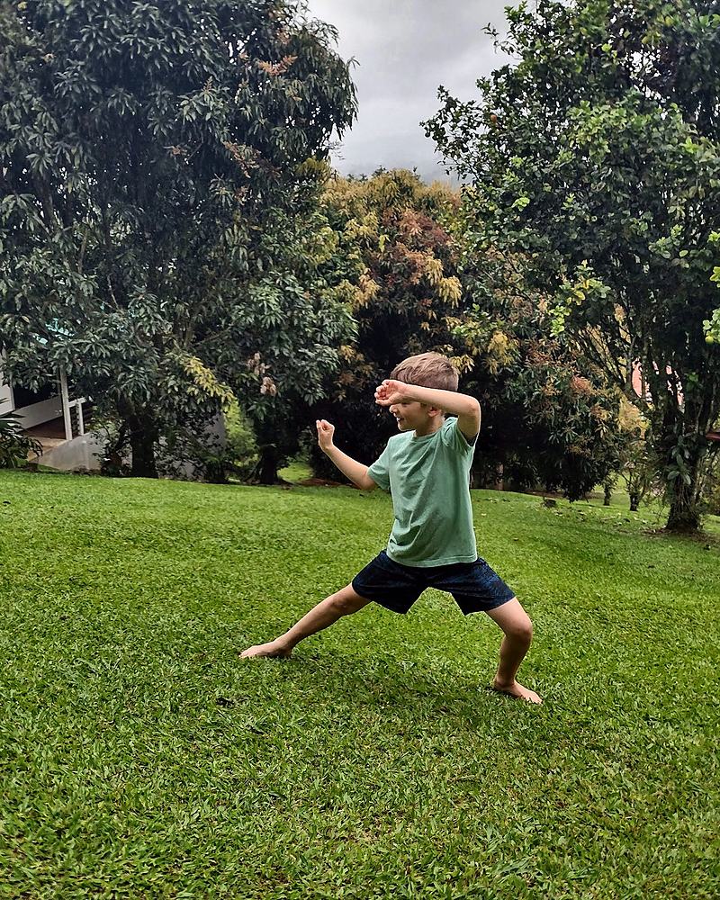 Child caught mid-run across a lawn, arms out