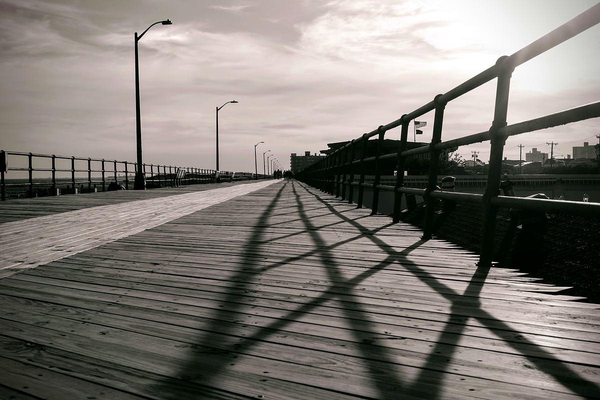 Pier railing casting a hard repeating shadow across the boards