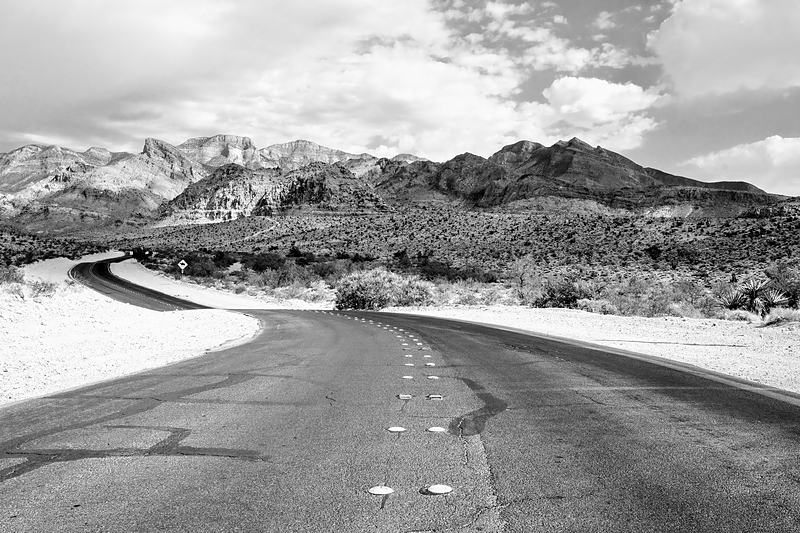 Monochrome road curving into snowbound mountains