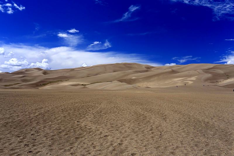 Sand dune ridge under a deep blue sky, reduced to two shapes