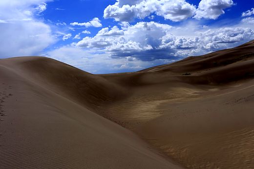 A single dune curve against open sky