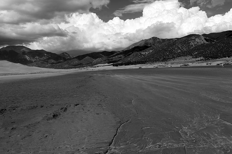 Black and white dunes under a bank of cloud