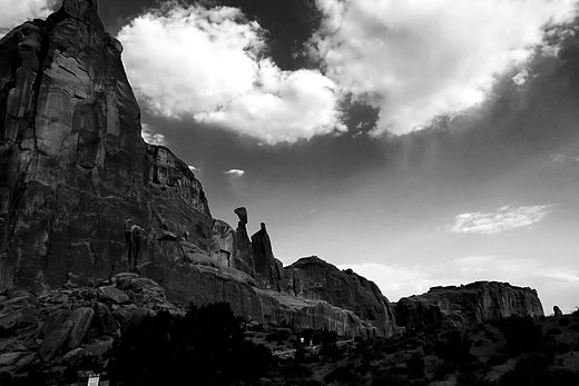 Black and white rock spire against piled cloud