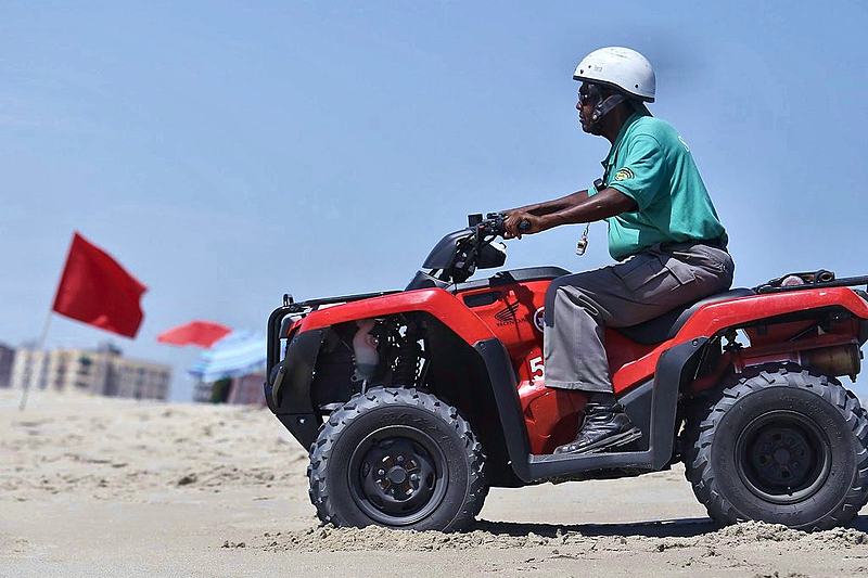 Beach patrol rider crossing the sand on a quad bike