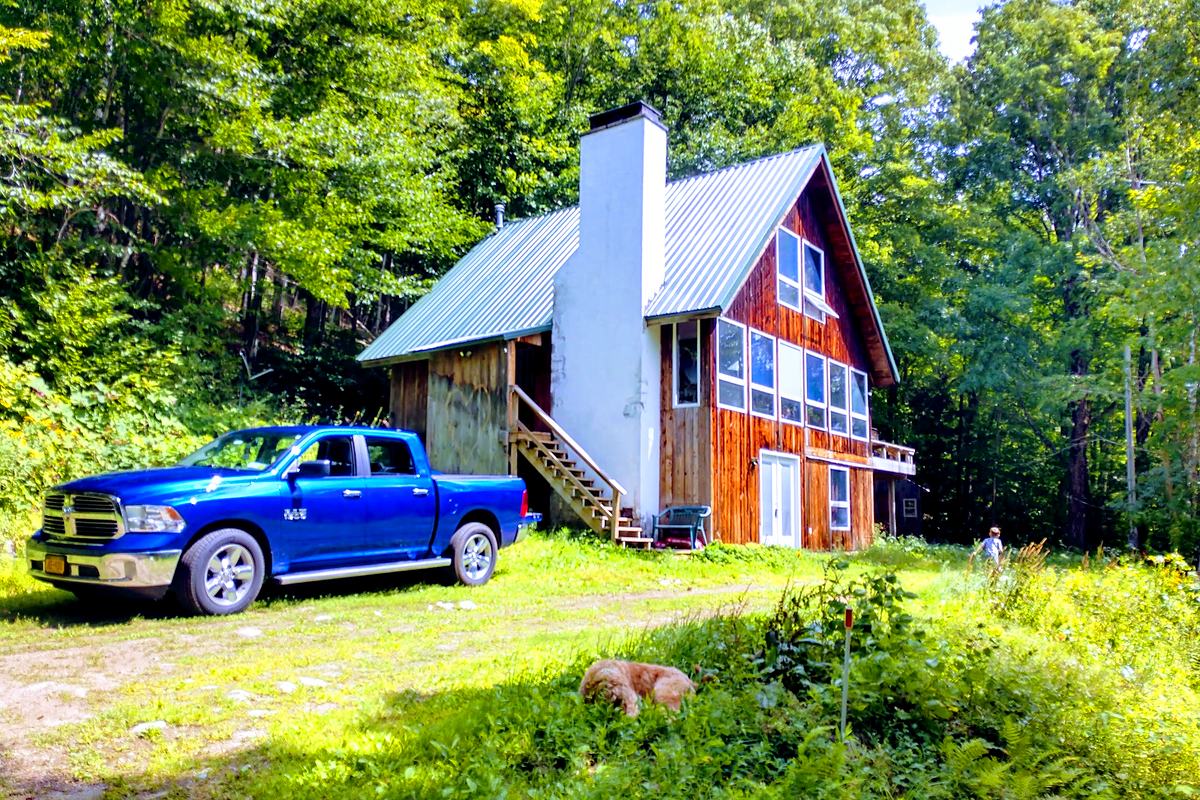 Timber house with a metal roof and a pickup on the drive
