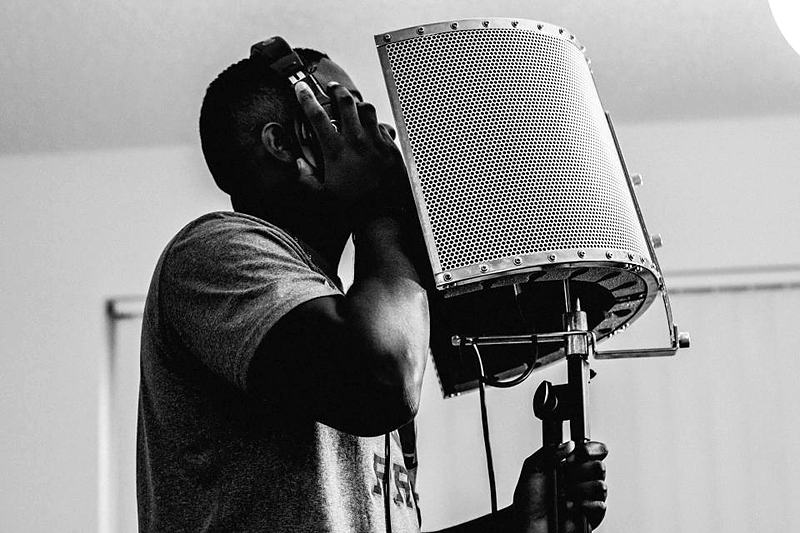 Reference frame: a vocalist at the microphone, in monochrome