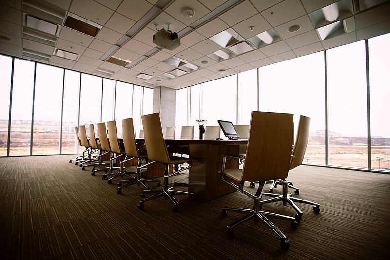 Reference frame: boardroom table and chairs before a wall of windows