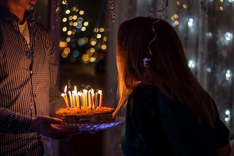 Reference frame: a lit birthday cake carried through a dark room