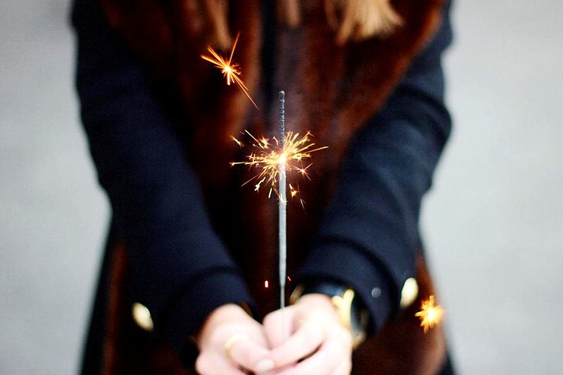 Reference frame: a sparkler held in a pair of hands at dusk