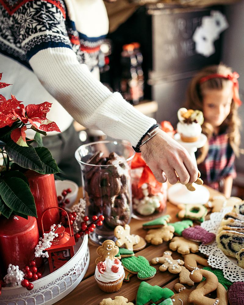 Reference frame: a child reaching across a table for decorated biscuits