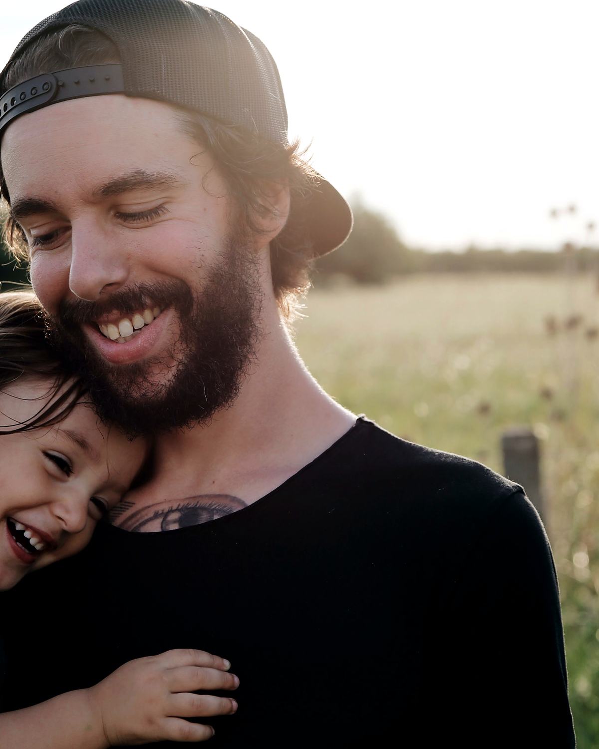 Reference frame: a father holding a laughing child up in a field