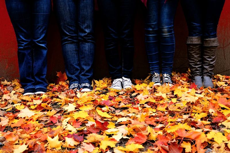 Reference frame: a family's feet gathered in a drift of autumn leaves