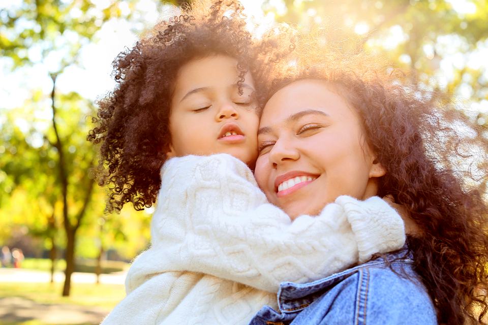 Reference frame: a mother holding her daughter close, backlit