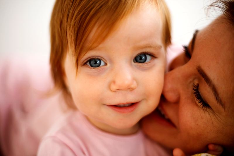 Reference frame: an older sibling kissing the new baby