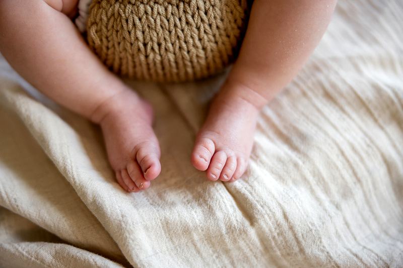 Reference frame: newborn feet on a cream blanket