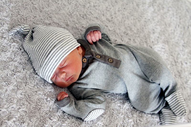 Reference frame: a newborn asleep, wrapped, in a striped hat