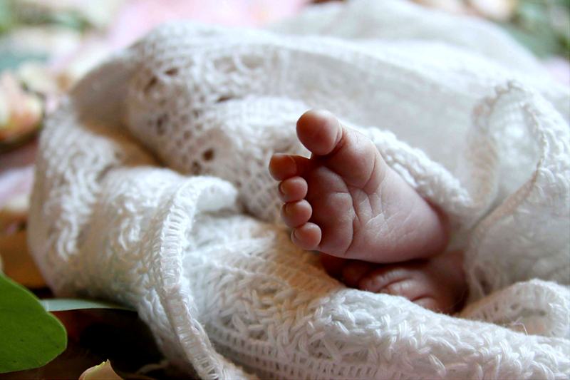 Reference frame: newborn feet against knitted wool