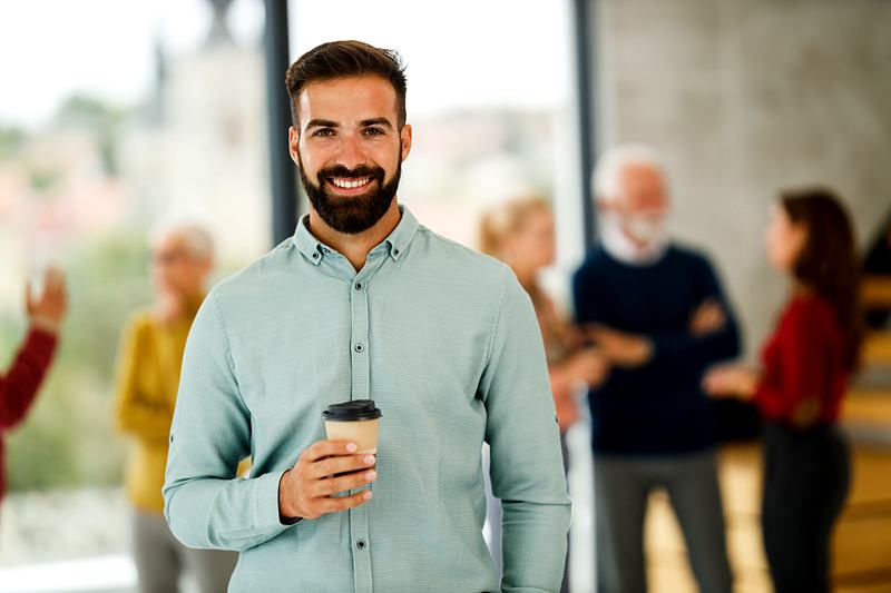 Reference frame: a professional portrait with the office behind and coffee in hand