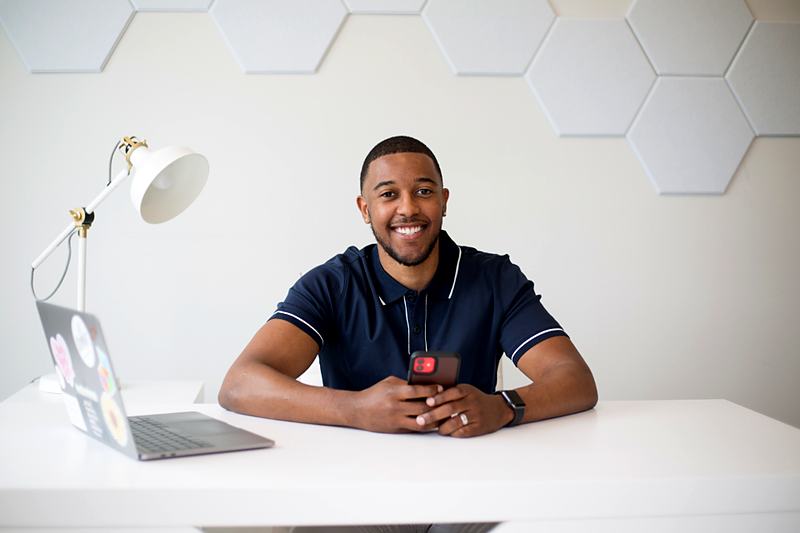 Reference frame: a seated portrait at a desk against a clean backdrop