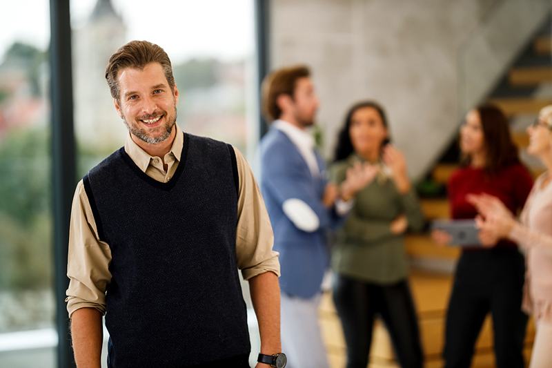 Reference frame: a professional portrait with a meeting going on behind