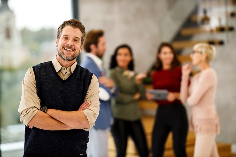 Reference frame: a professional portrait, arms folded, an open office behind