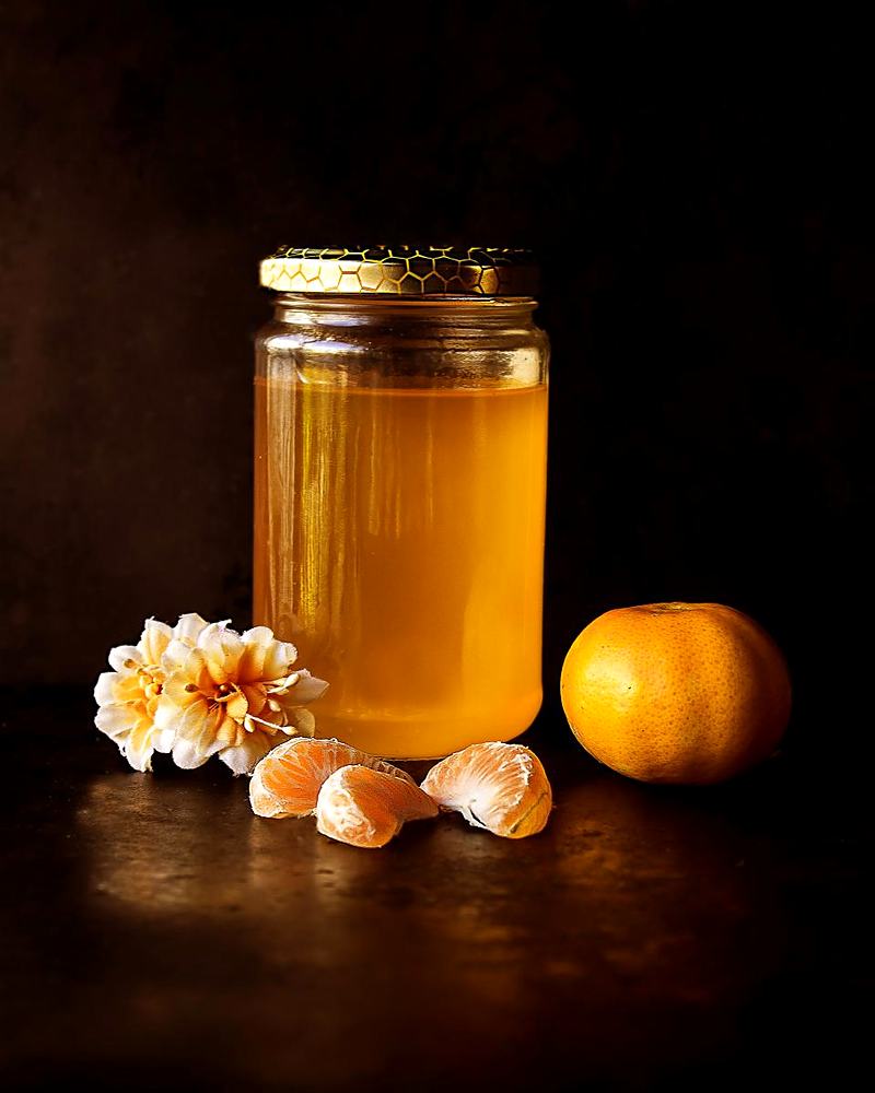 Reference frame: a honey jar still life on dark wood