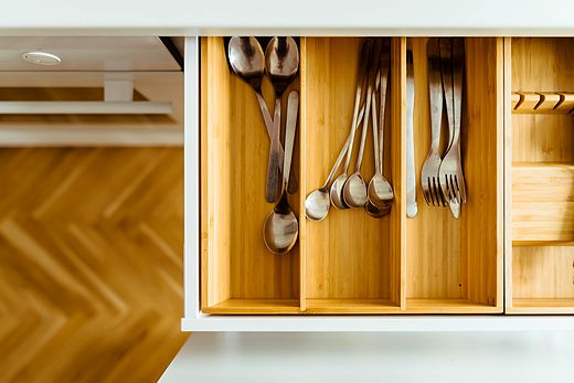 Reference frame: open kitchen drawer with cutlery in a wooden insert