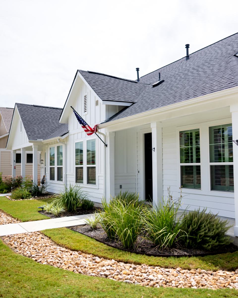 Reference frame: a white clapboard house behind a planted front walk