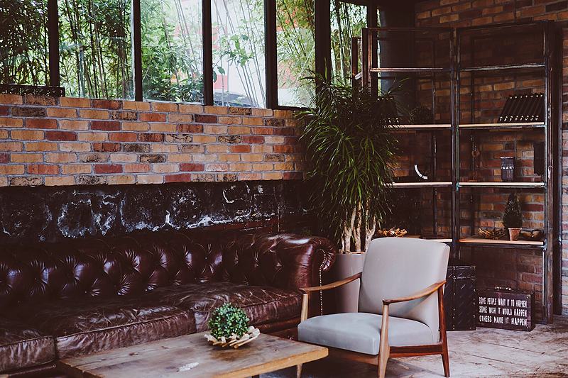 Reference frame: interior lounge with brick wall and window planting