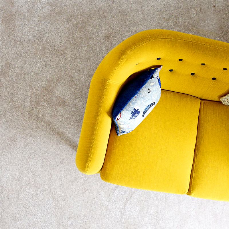 Reference frame: yellow sofa shot from overhead on pale terrazzo