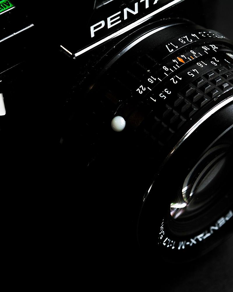 Reference frame: low-key study of a lens barrel and aperture ring