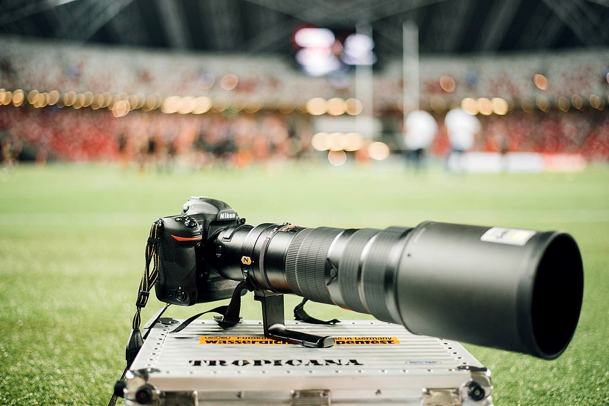 Reference frame: long telephoto lens on a body at the edge of a field