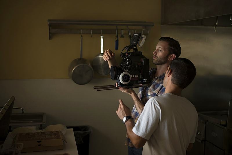 Reference frame: operator shouldering a cinema camera in a kitchen