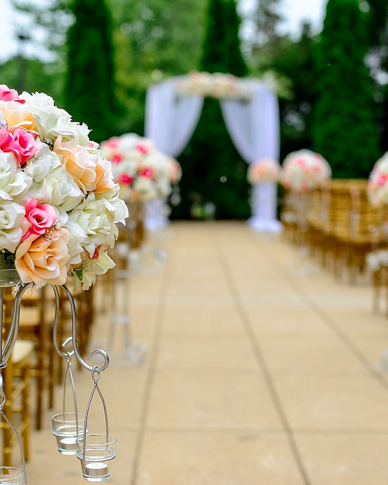 Reference frame: aisle set for a ceremony with tall floral arrangements