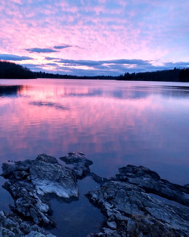 Pink dusk over rocks and still water